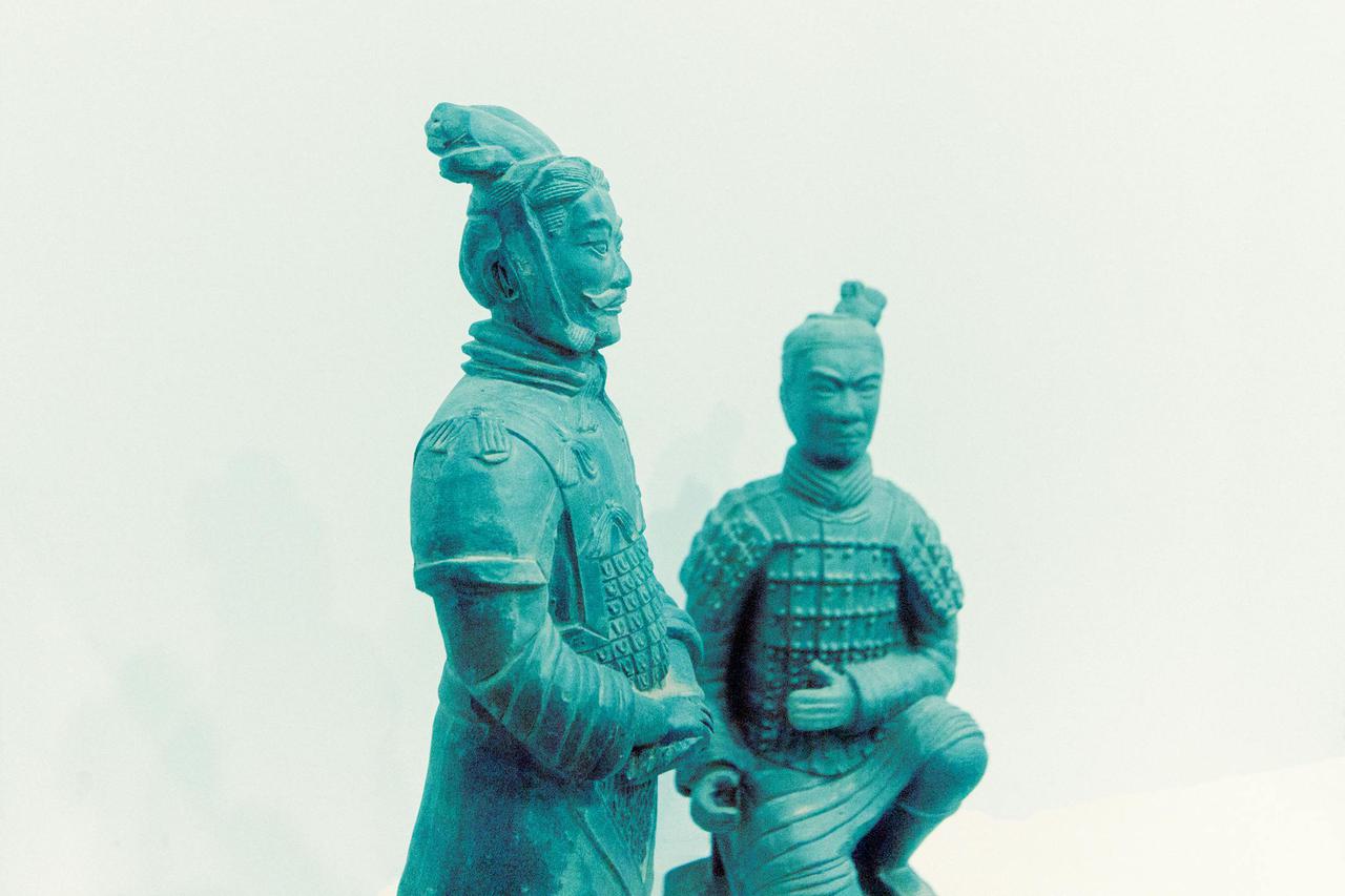 Two terracotta warrior statues displayed on a white backdrop.